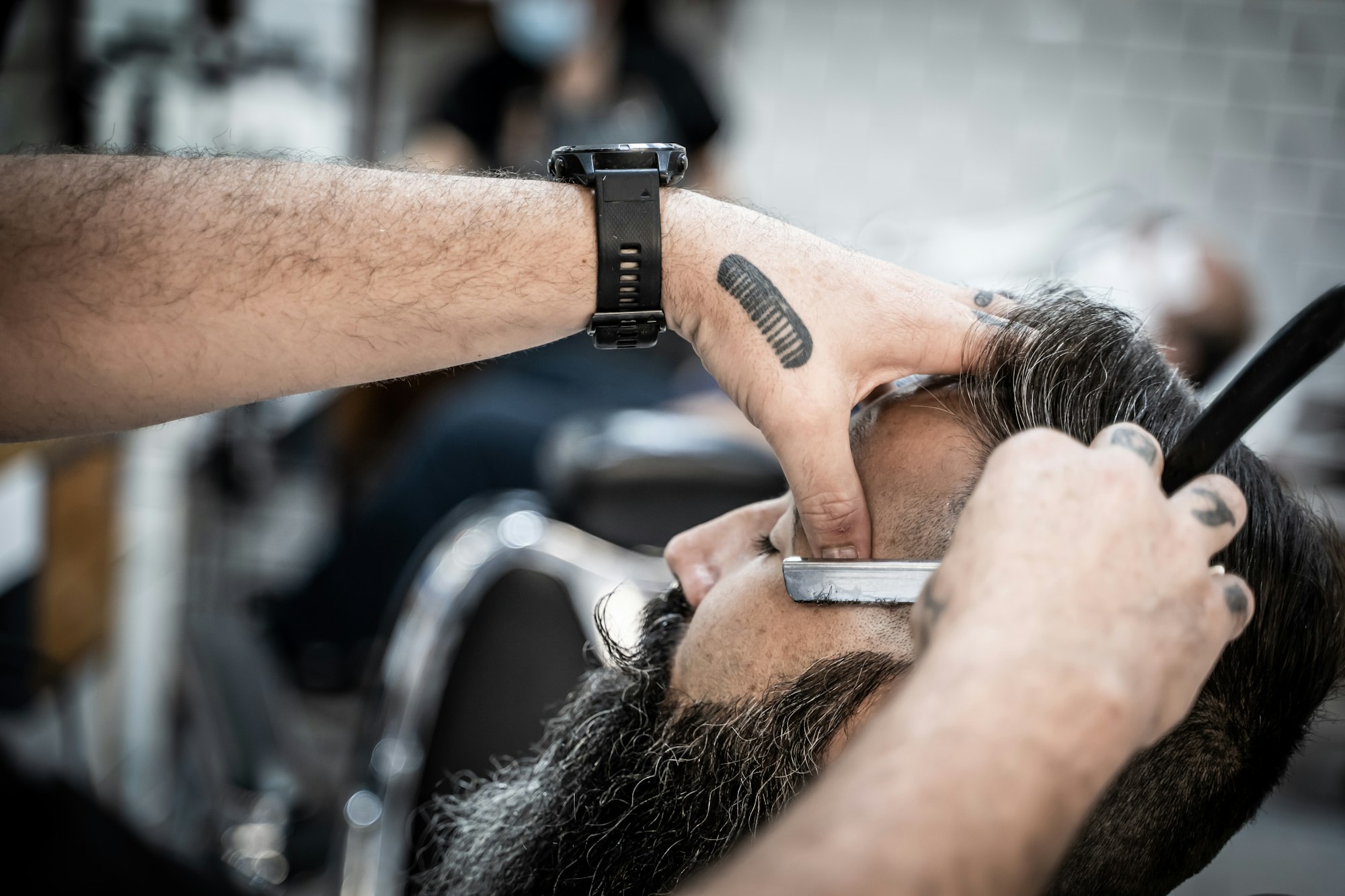 Barber shaving a client in a barber shop